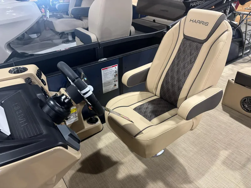 Slide: The Image of Captain's chair and helm of 2025 Harris Sunliner 230 SL pontoon boat, featuring luxury seating. - 3