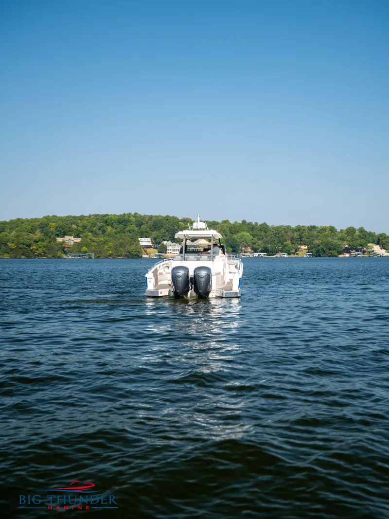 Slide: The Image of Opus 12 boat 2024 on a calm lake with wooded shoreline. - 25