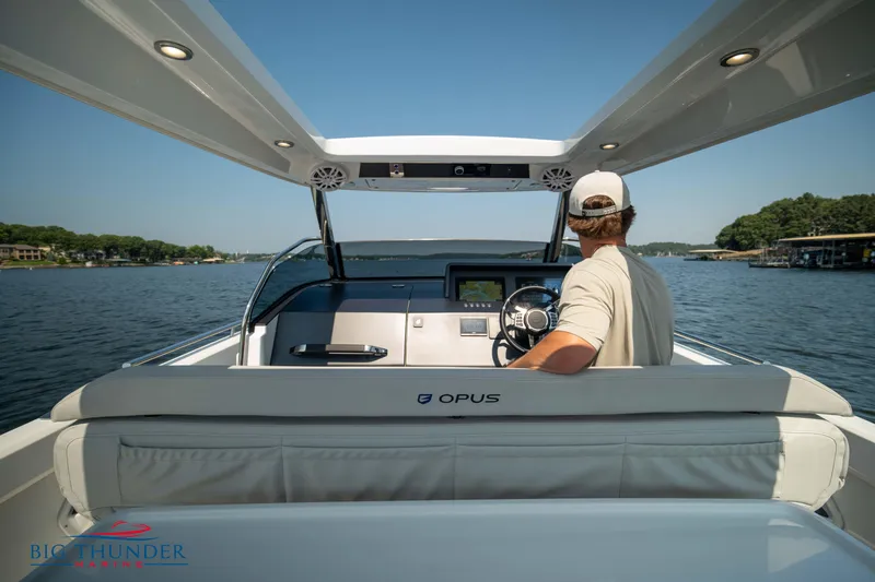 Slide: The Image of Man steering 2024 Opus 12 boat on calm lake. - 45