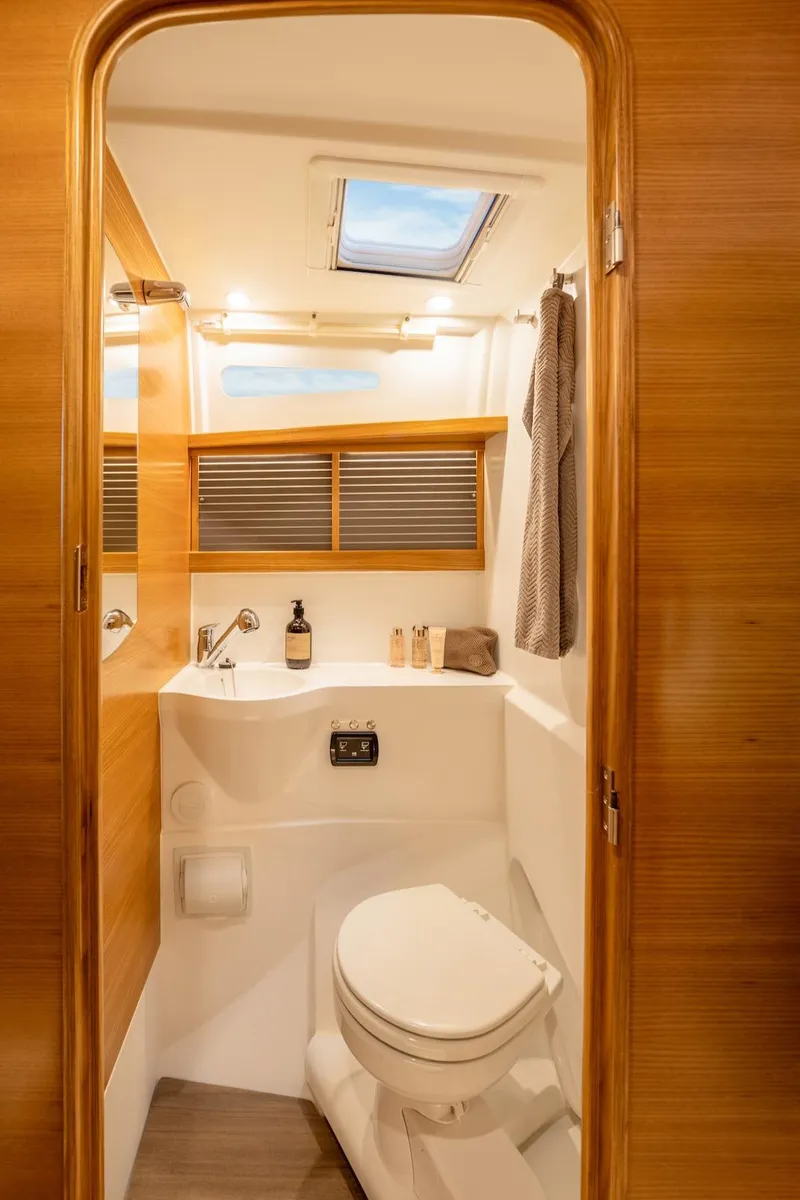 Slide: The Image of Modern yacht bathroom with wooden accents, skylight, and compact design in Dragonfly 36, 2027 model. - 14
