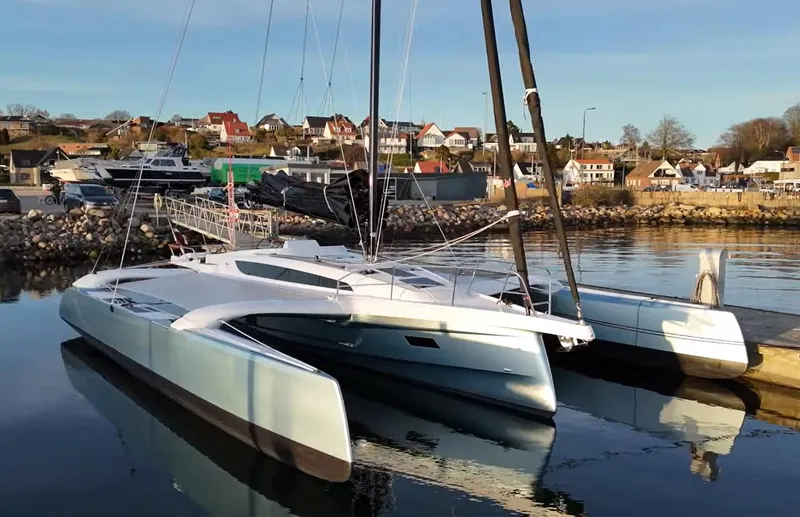 Slide: The Image of Modern Dragonfly 36 trimaran docked in a serene marina, 2027 model. - 4