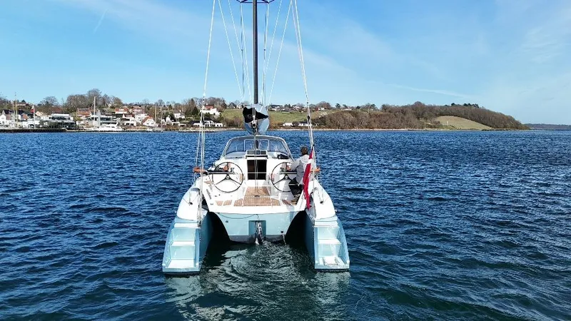 Slide: The Image of Sailing catamaran Dragonfly 36 on calm waters, scenic coastal background, clear blue sky. - 7