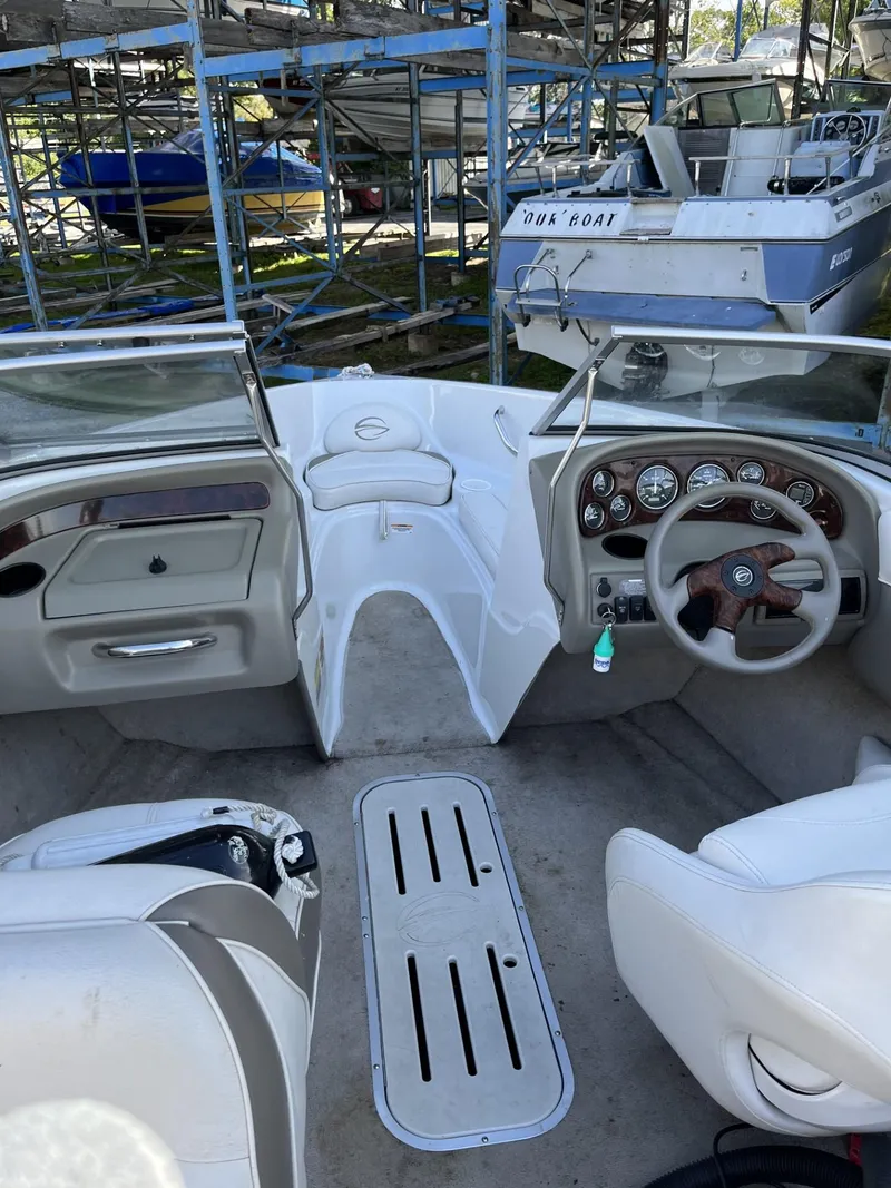 Slide: The Image of 2005 Crownline 180 BR boat interior with steering wheel and dashboard in storage area. - 11