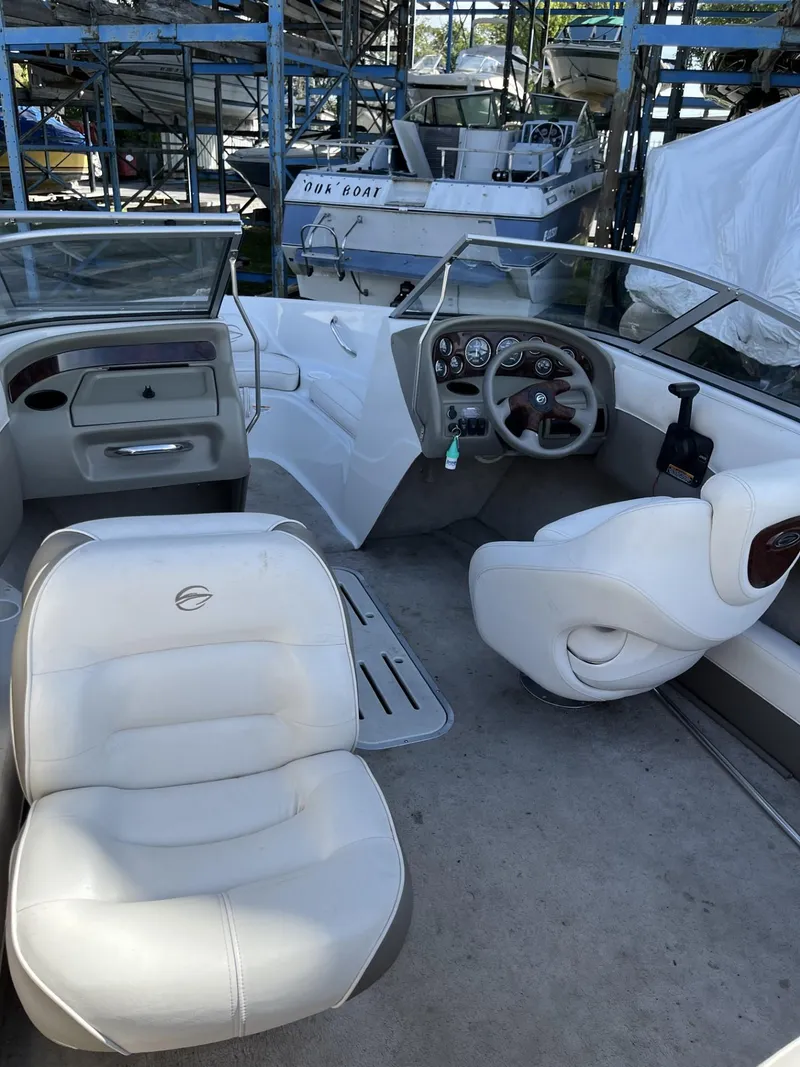 Slide: The Image of 2005 Crownline 180 BR boat interior with white seating and dashboard. - 8