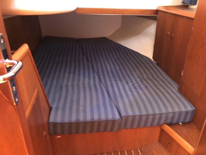 Slide: The Image of Cozy cabin interior of 2001 Jeanneau 45.2 sailboat with striped bedding. - 18