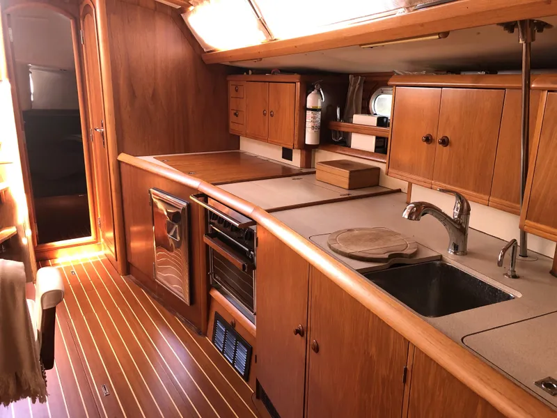 Slide: The Image of Interior of 2001 Jeanneau 45.2 yacht with wooden cabinetry and modern kitchen amenities. - 7