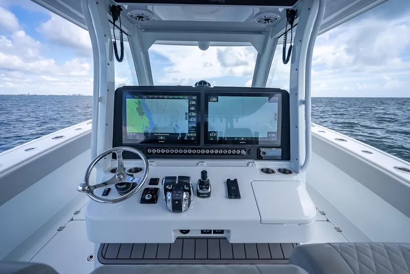 Slide: The Image of Freeman 43 boat dashboard with dual navigation screens, steering wheel, and controls, 2023 model. - 22