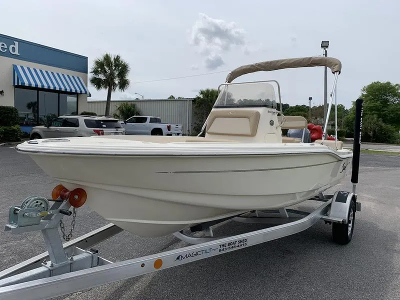 Slide: The Image of 2025 Scout 175 Sportfish boat on trailer, parked outdoors near a building. - 7