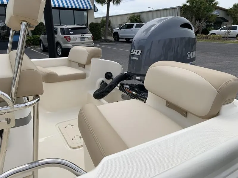 Slide: The Image of 2025 Scout 175 Sportfish boat interior with Yamaha 90 engine, beige seating, and outdoor setting. - 8
