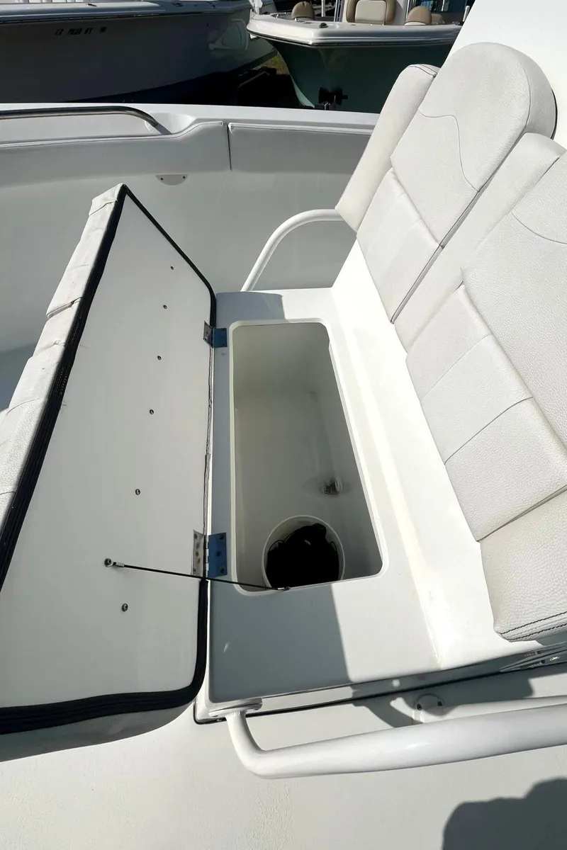 Slide: The Image of Open storage compartment on a 2018 Clearwater 2508 boat with cushioned seating. - 11
