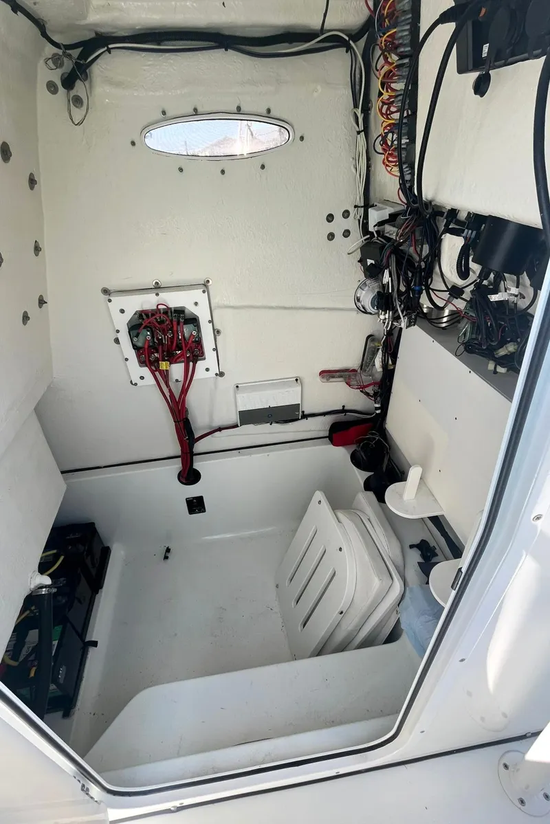 Slide: The Image of Interior of a 2018 Clearwater 2508 boat showing wiring and storage space. - 12