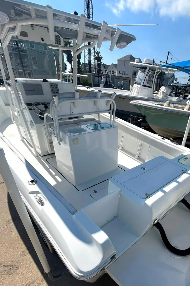 Slide: The Image of 2018 Clearwater 2508 boat with center console and seating, docked under a clear sky. - 17