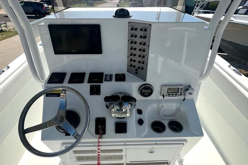 Slide: The Image of 2018 Clearwater 2508 boat console with steering wheel, controls, and navigation equipment. - 2