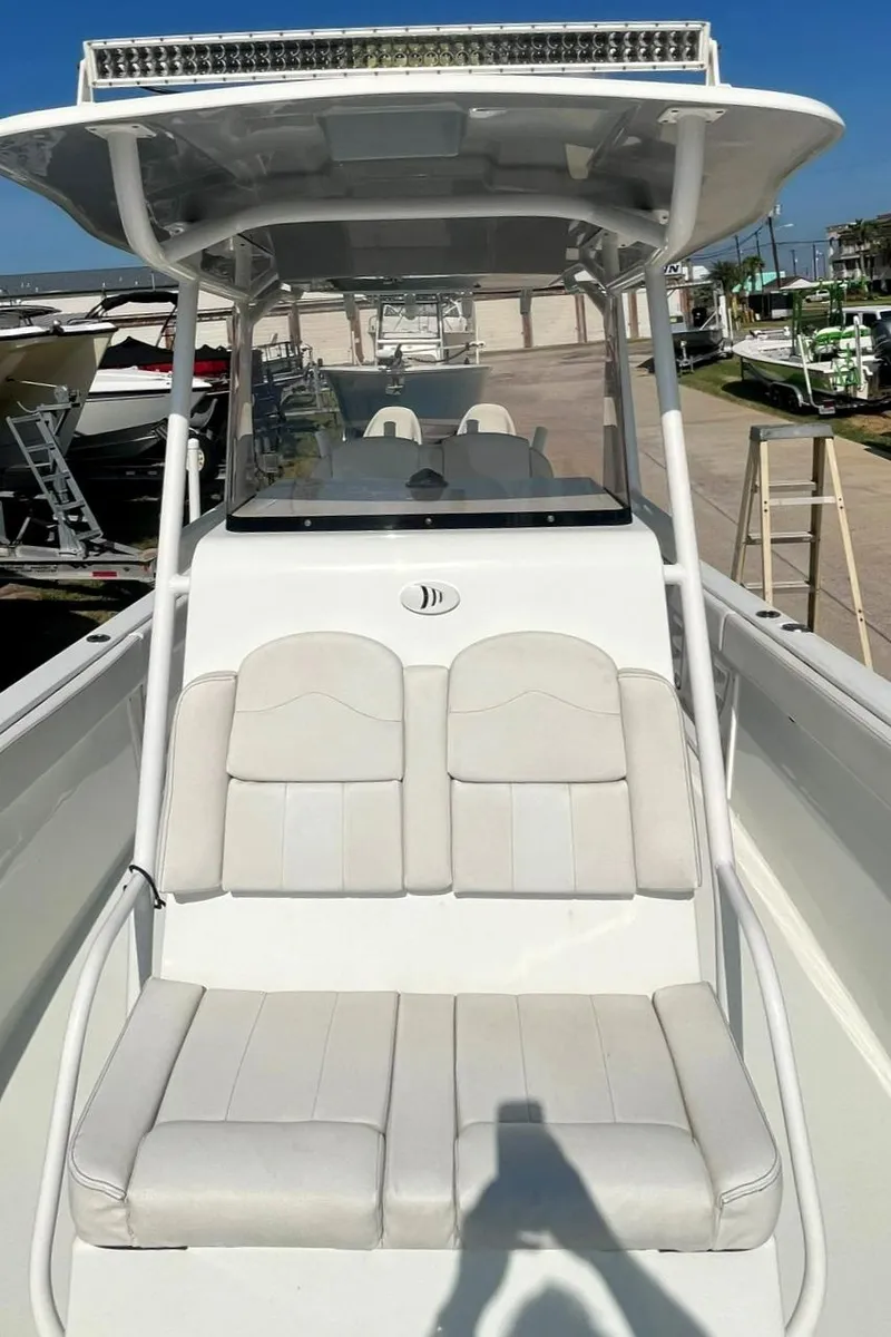 Slide: The Image of 2018 Clearwater 2508 boat with white seating and T-top in a marina. - 8