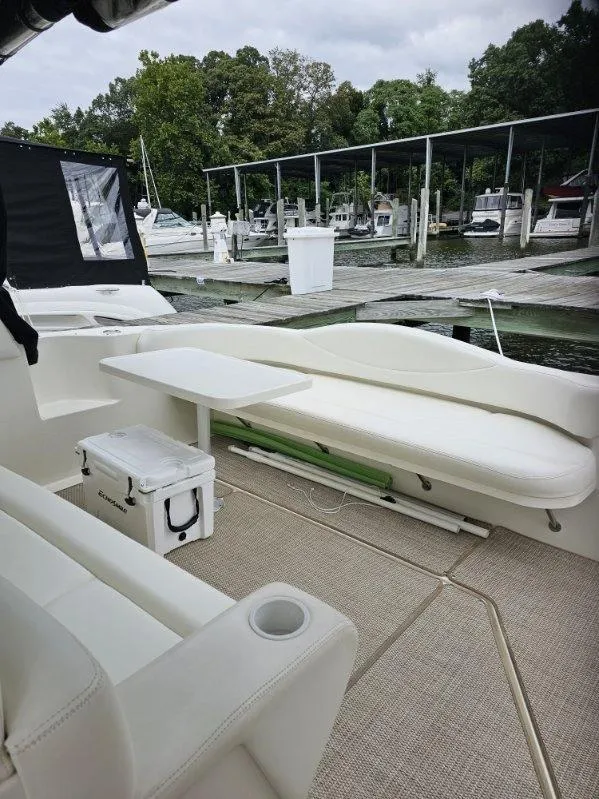 Slide: The Image of 2002 Sea Ray 410 Sundancer yacht interior with seating and table at marina. - 15