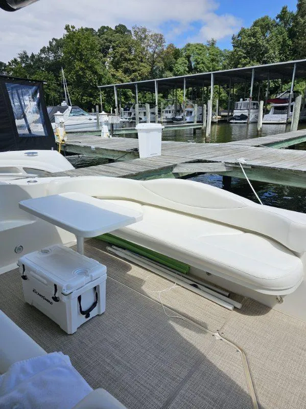 Slide: The Image of 2002 Sea Ray 410 Sundancer yacht docked, featuring outdoor seating and cooler. - 16