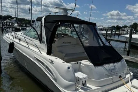 Slide: The Image of 2002 Sea Ray 410 Sundancer docked at marina under blue sky. - 2