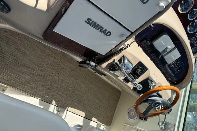 Slide: The Image of 2002 Sea Ray 410 Sundancer helm with Simrad electronics and wooden steering wheel. - 27