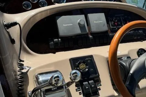 Slide: The Image of 2002 Sea Ray 410 Sundancer helm with Raymarine electronics and wooden steering wheel. - 28