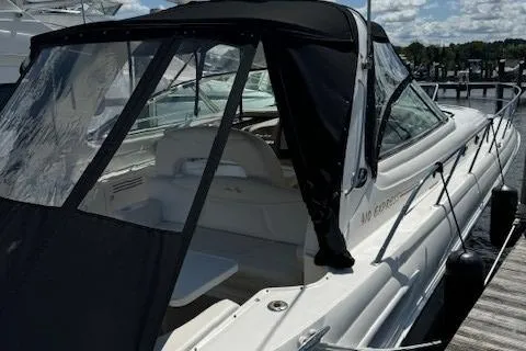 Slide: The Image of 2002 Sea Ray 410 Sundancer boat docked with black canopy and white interior. - 3