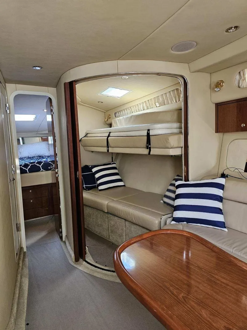 Slide: The Image of Interior of 2002 Sea Ray 410 Sundancer with cozy seating and striped pillows. - 33