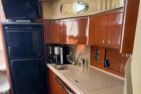 Slide: The Image of 2002 Sea Ray 410 Sundancer yacht kitchen with wood cabinets and modern appliances. - 34