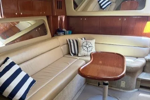 Slide: The Image of Luxurious interior of 2002 Sea Ray 410 Sundancer yacht with beige seating and wooden table. - 35