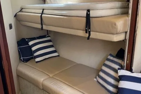 Slide: The Image of 2002 Sea Ray 410 Sundancer cabin with beige seating and striped pillows. - 37