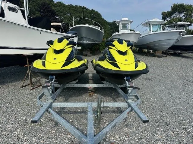 Slide: The Image of Two 2021 Yamaha WaveRunner VX Limited jet skis on a trailer, parked near boats. - 2