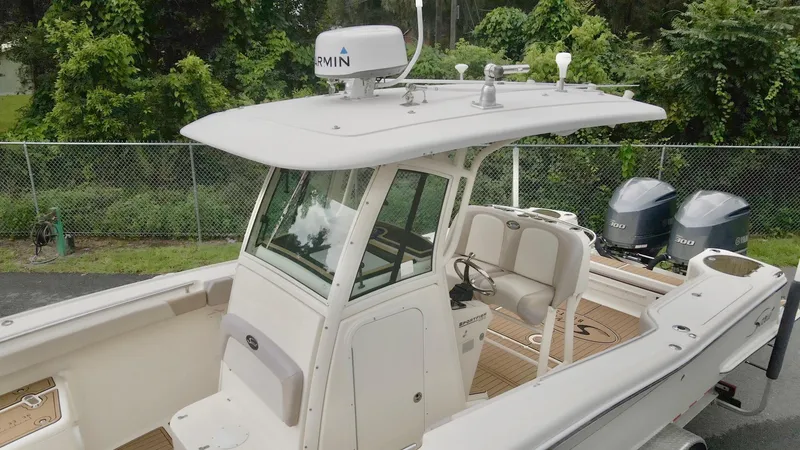 Slide: The Image of 2009 Scout 282 Sportfish boat with dual engines and Garmin radar, docked near greenery. - 12
