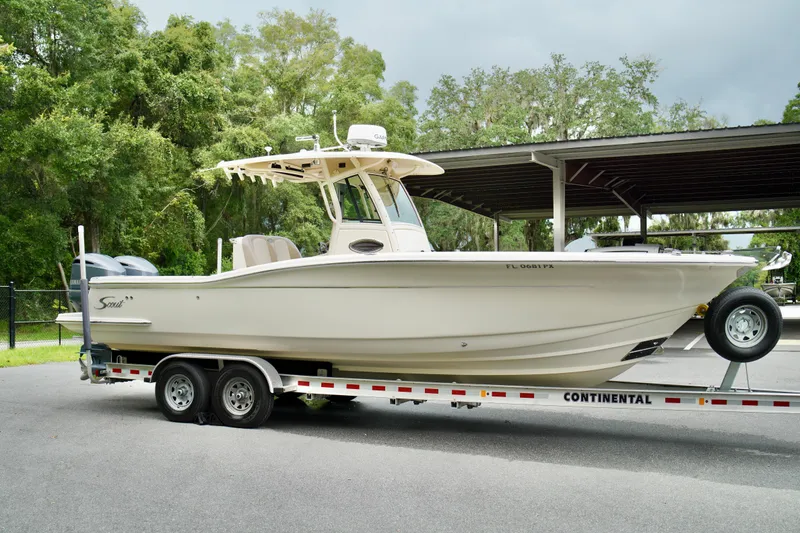Slide: The Image of 2009 Scout 282 Sportfish boat on trailer, parked outdoors. - 2