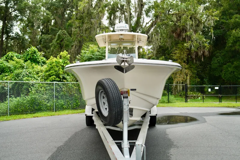 Slide: The Image of 2009 Scout 282 Sportfish boat on trailer, surrounded by lush greenery. - 4