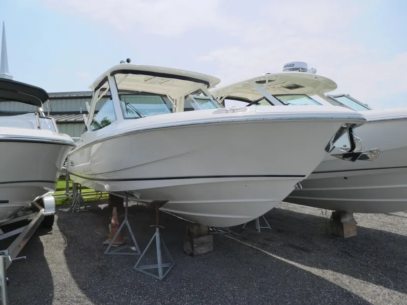Slide: The Image of 2024 Boston Whaler 320 Vantage boat on display in a marina. - 1