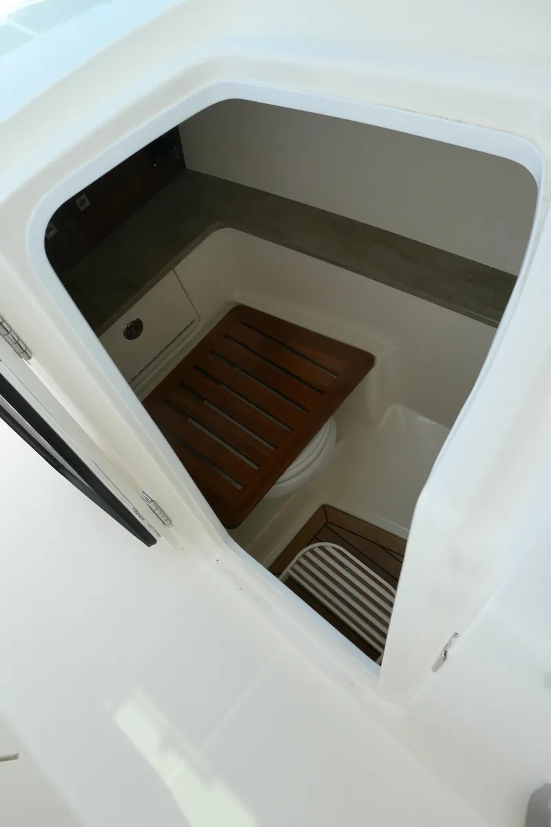 Slide: The Image of 2024 Boston Whaler 320 Vantage interior cabin with wooden seating. - 11