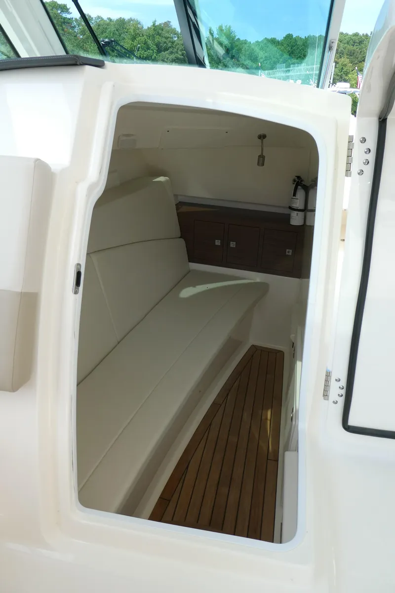 Slide: The Image of 2024 Boston Whaler 320 Vantage cabin interior with seating and wood flooring. - 12