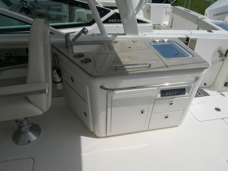 Slide: The Image of 2024 Boston Whaler 320 Vantage boat interior with kitchenette and seating area. - 6