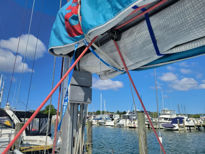 Slide: The Image of Nelson Marek IOR 50 Racing Sailboat docked, vibrant sails, clear blue sky, marina background. - 13
