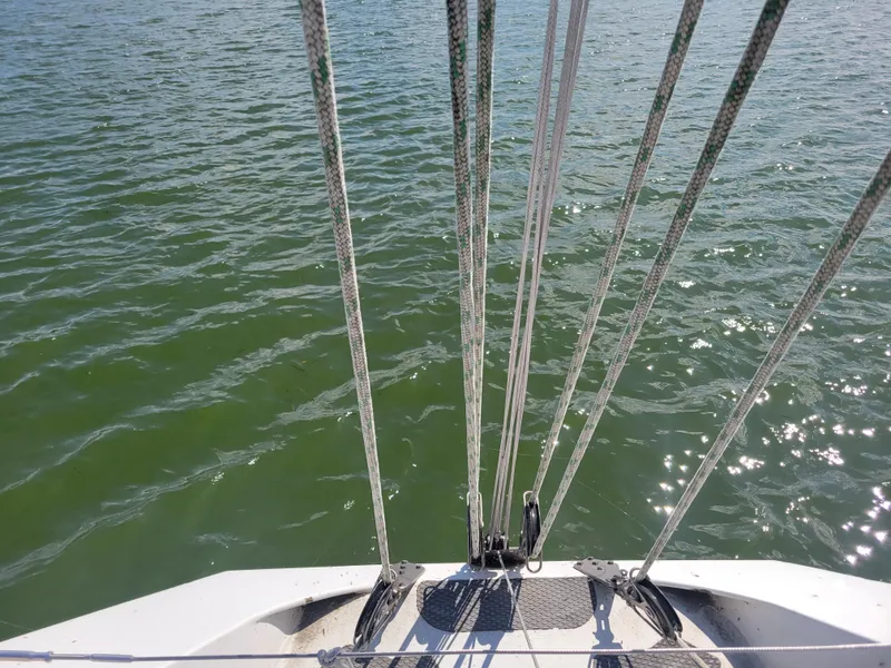 Slide: The Image of Nelson Marek IOR 50 Racing Sailboat deck view with ropes over green water. - 8