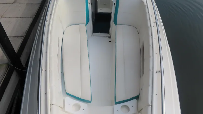 Slide: The Image of 1997 Envision Intruder 3200 boat interior with white seating and teal accents. - 10
