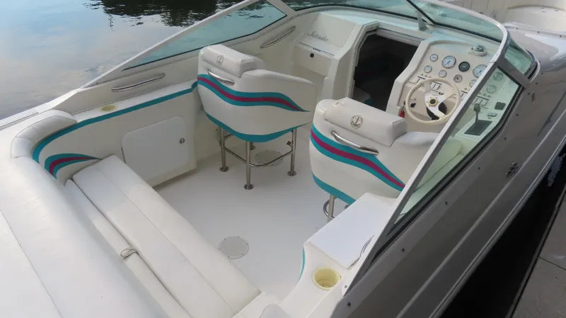 Slide: The Image of 1997 Envision Intruder 3200 boat interior with white seating and colorful accents. - 3