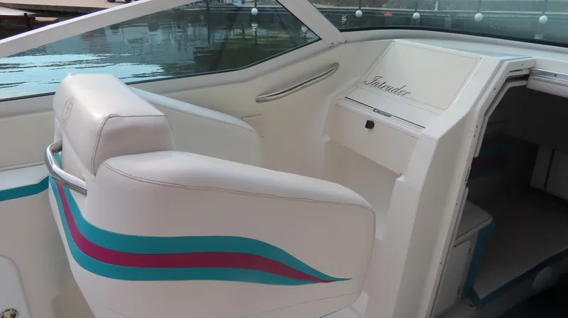 Slide: The Image of 1997 Envision Intruder 3200 boat interior with white seats and colorful stripes. - 7