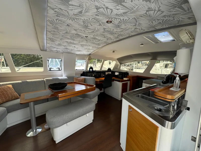 Slide: The Image of Interior of 2010 Outremer 49 yacht with modern seating and kitchen area. - 13