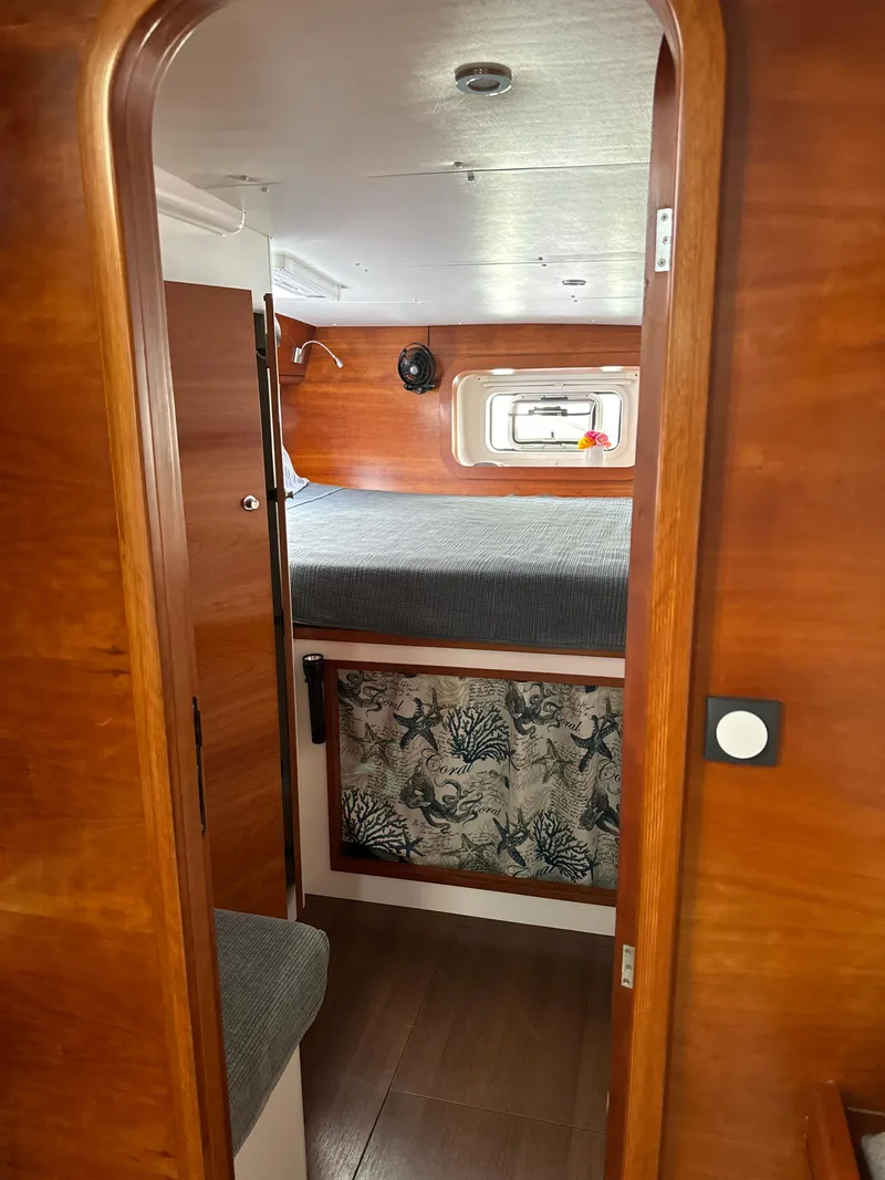 Slide: The Image of Cabin interior of 2010 Outremer 49 sailboat with wooden finish and cozy bed. - 19