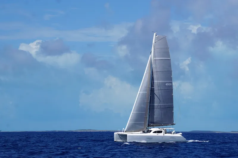 Slide: The Image of Outremer 49 catamaran sailing on open sea under clear blue sky, 2010 model. - 2
