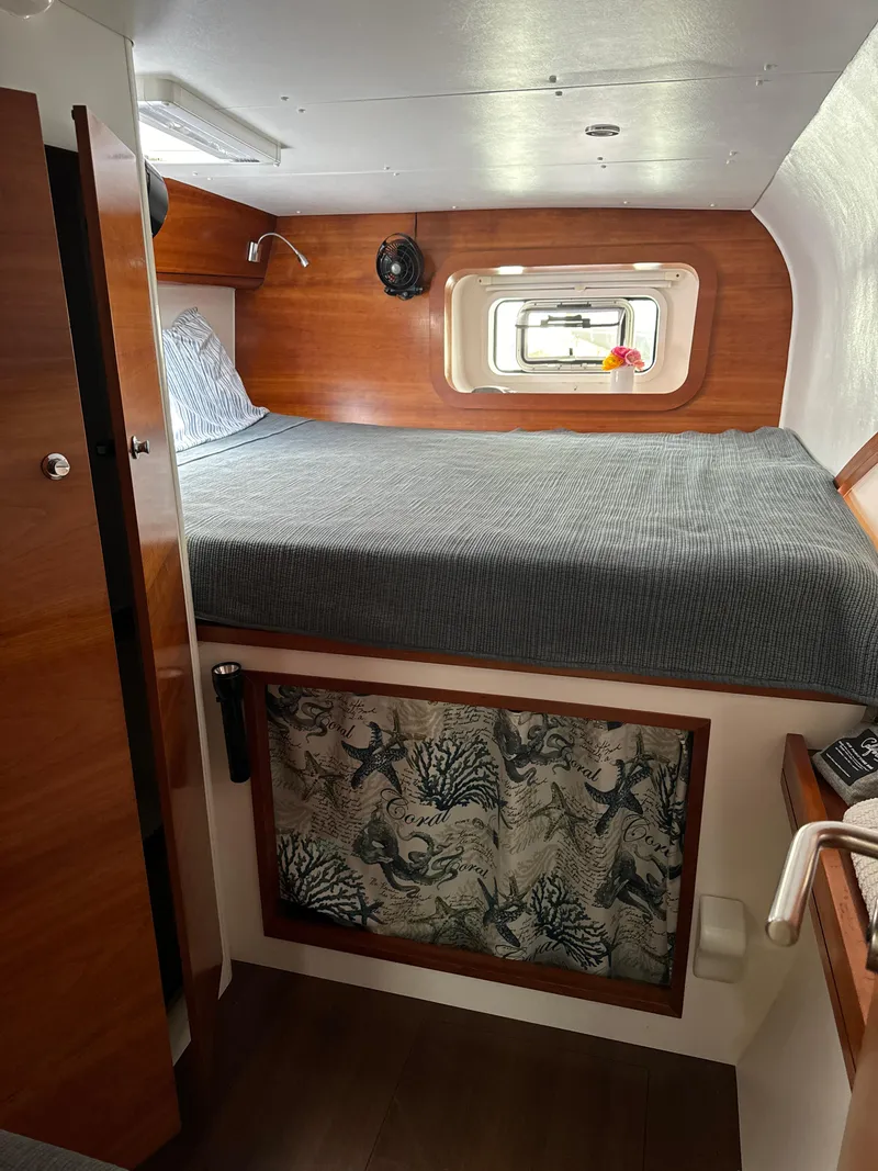 Slide: The Image of Cozy cabin interior of 2010 Outremer 49 sailboat with wooden accents and a comfortable bed. - 20