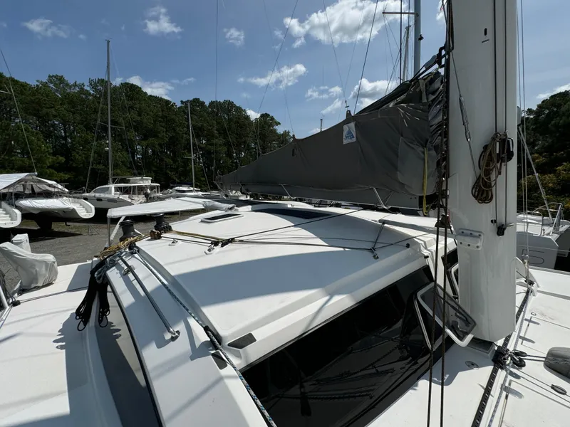 Slide: The Image of 2010 Outremer 49 sailboat docked, featuring sleek design and rigging, under a clear sky. - 26