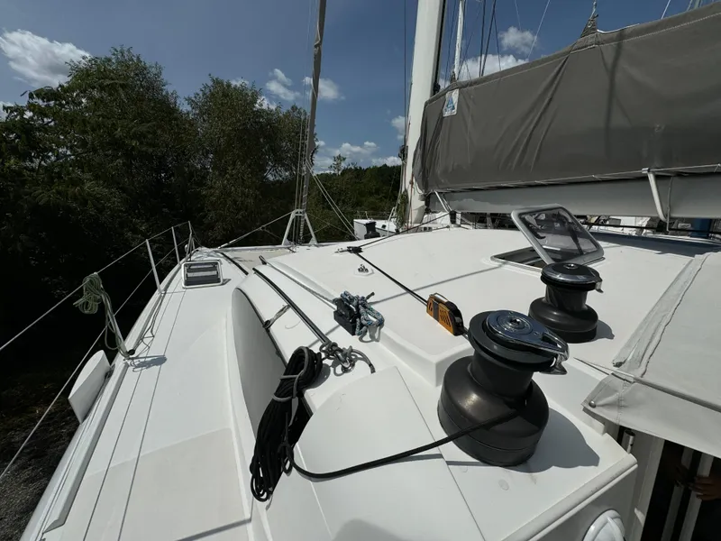 Slide: The Image of 2010 Outremer 49 sailboat deck with winches and rigging, set against a clear sky. - 35