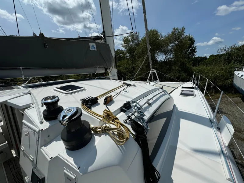 Slide: The Image of 2010 Outremer 49 sailboat deck with winches and rigging under a clear sky. - 40