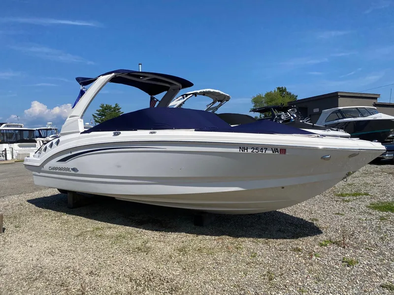 Slide: The Image of 2019 Chaparral 246 SSi boat on gravel lot under clear blue sky. - 2