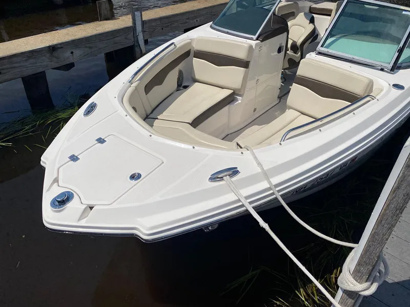 Slide: The Image of 2019 Chaparral 246 SSi boat docked, featuring sleek design and comfortable seating. - 3